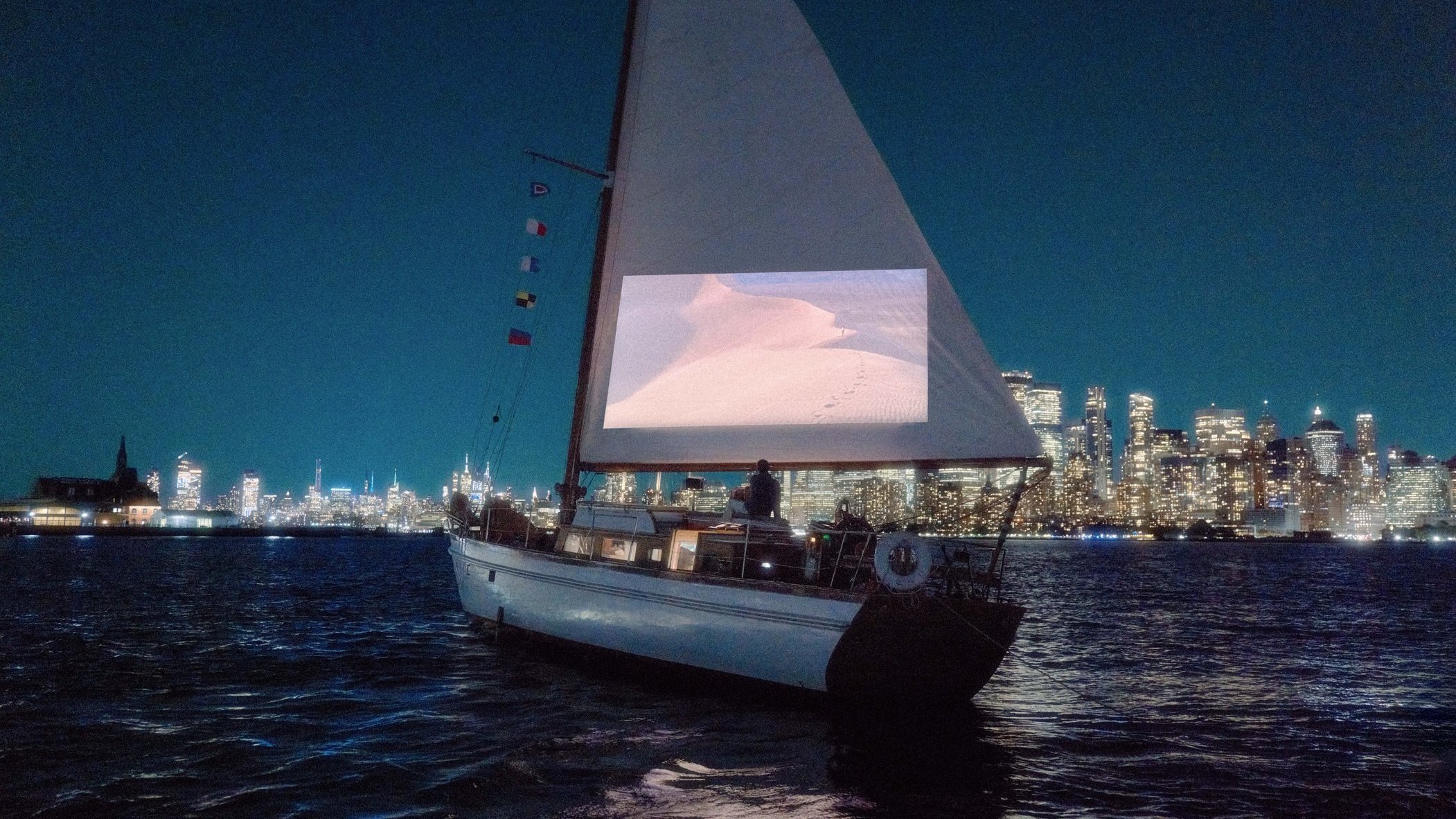 Segelboot vor Skyline, Segel dient als Projektionsfläche.